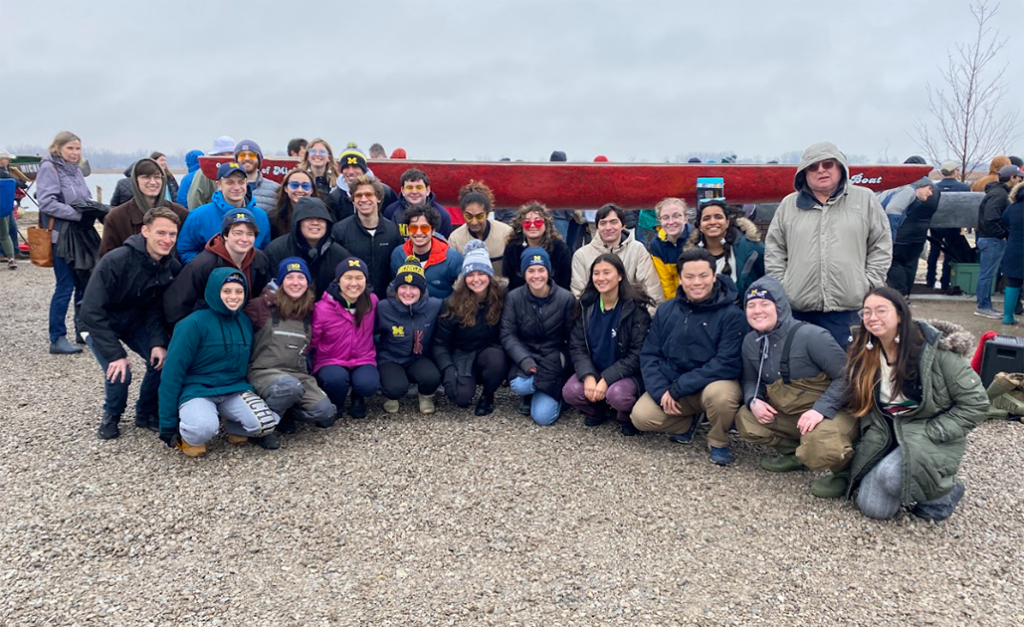 Concrete Canoe team members posed outside in front of their canoe at a competition.